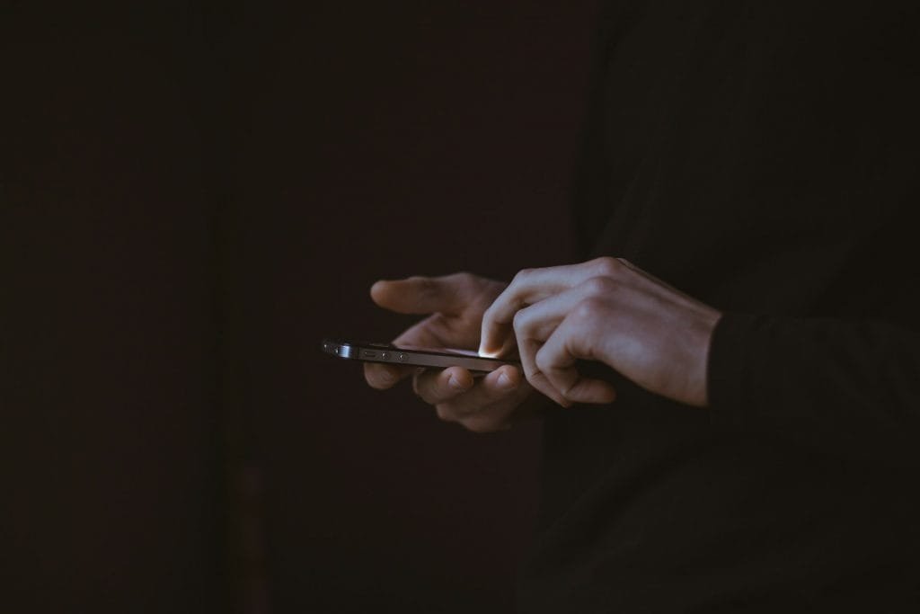 Homem usando o celular via Gilles Lambert/Unsplash