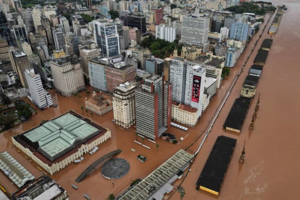 Na foto, prédios e armazéns de um cais estão em ruas quase inteiramente alagadas.