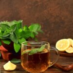 Medicinal herbal tea or infusion of peppermint with lemon with flowers, concept of alternative traditional medicine, collection of useful herbs for treatment according to folk recipes,