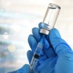 (Não usar depois da publicação. Em caso de dúvidas, falar com Foto) Medical personnel filling a syringe needle with generic vaccine booster from vial